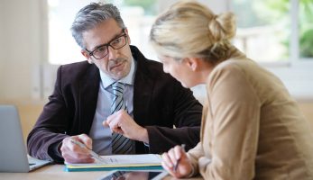 Male business man discussing with female colleague about a document