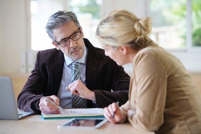 Male business man discussing with female colleague about a document