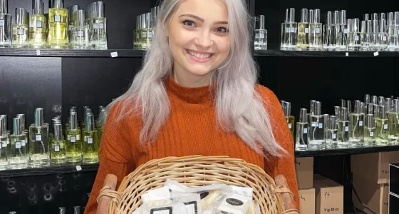 Black Point Perfumes Owner, Karolina Stonkute, holding basket of products in store